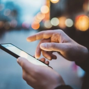 Anwender nutzt eine App auf dem Handy am Abend außerhalb des Büros