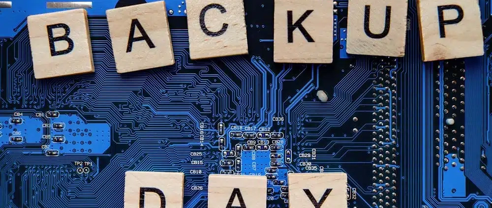 Holzwürfel auf einem Motherboard mit den Buchstaben: B A C K U P - D A Y