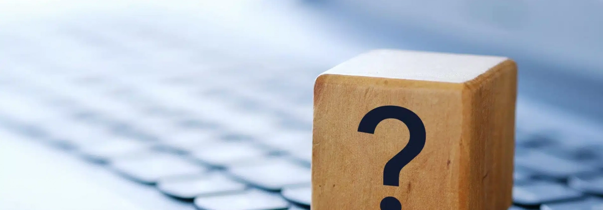 Holzwürfel mit einem "?" auf einer Notebooktastatur